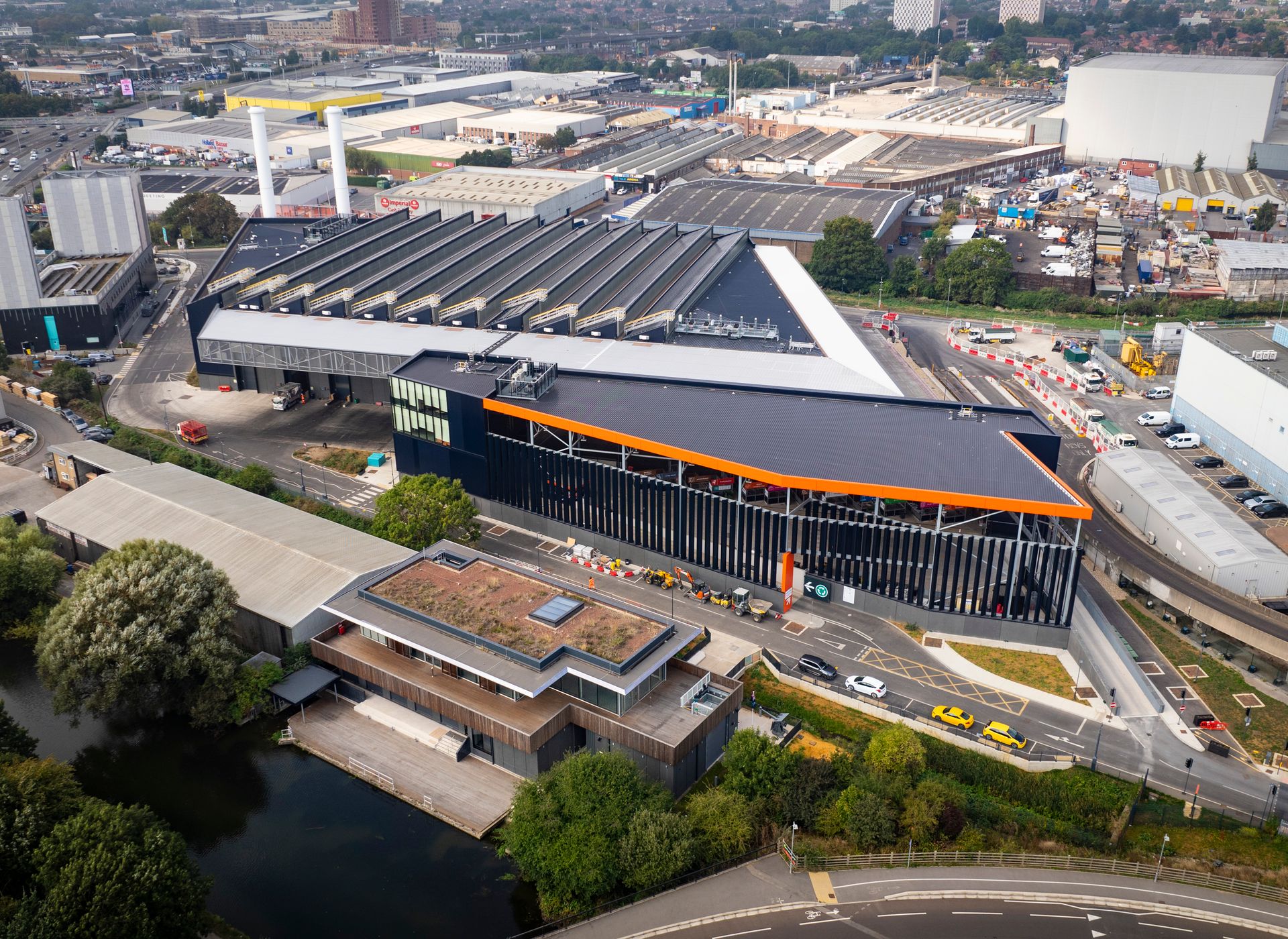 Race Cottam Associates Ltd — Aerial view of EcoPark South showing the RFPF with a distinctive sawtooth roof, set within a busy urban industrial area and road network. EcoPark Hous